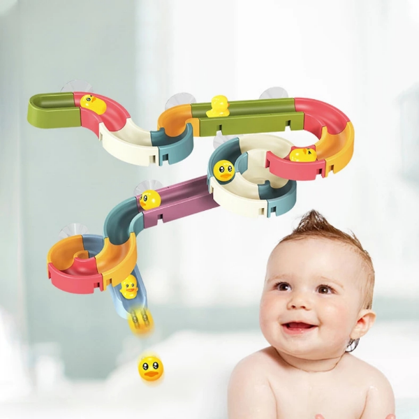 Colorful toy marble track with a baby smiling next to it on a light background