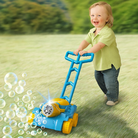 Child playing with a bubble machine outdoors on a grassy field