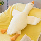 Plush toy goose on a yellow blanket with a book underneath